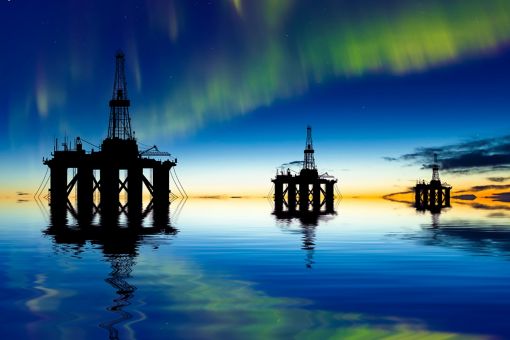 Oil rig at sea at night with northern lights
