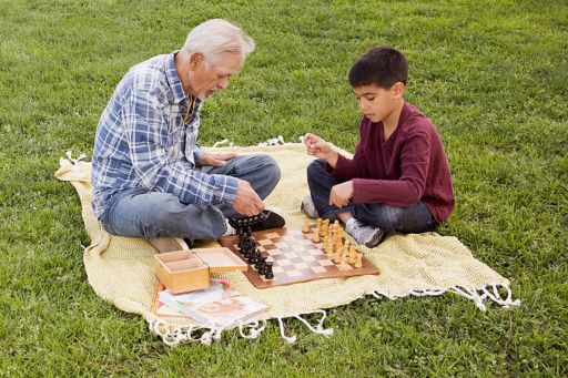 Grandpa and boy play chess