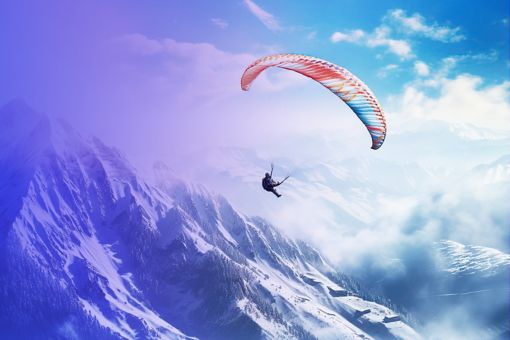 Paraglider flying above mountains