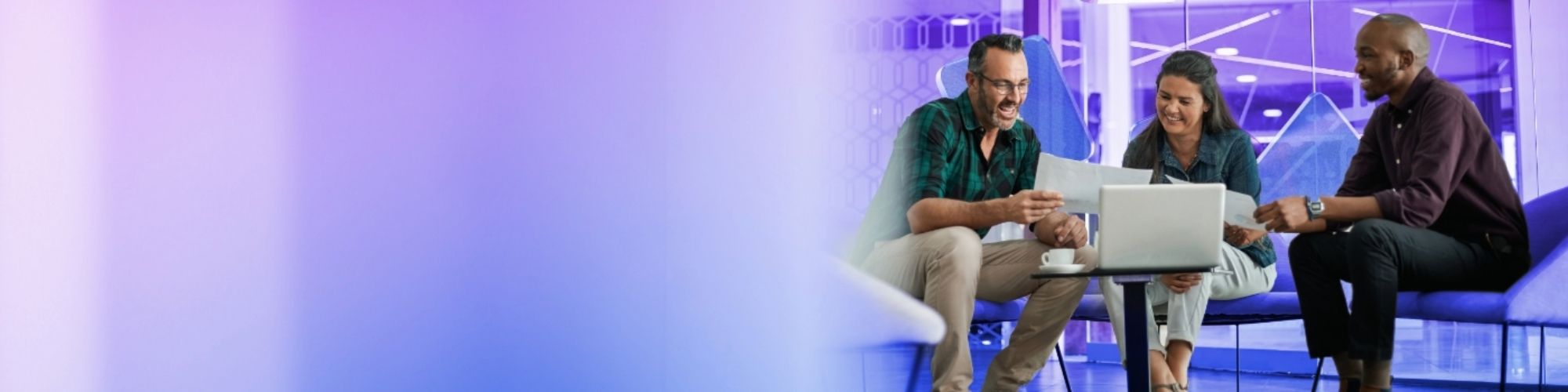 people sat on a table in discussion in an open plan office space