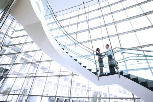 People meeting on curved stairs with big windows