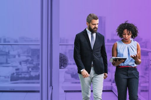 Two people walking next to a building