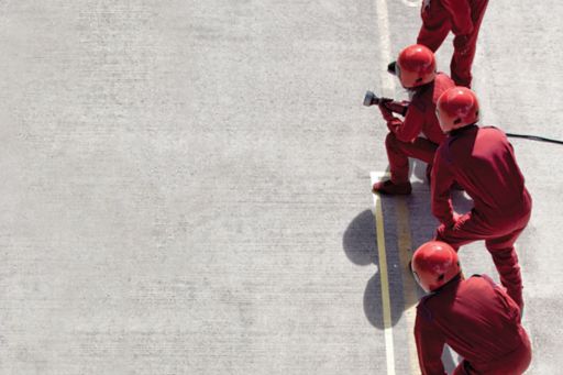 People wearing red uniform and working on road