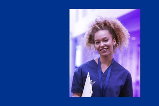 Person smiling whilst wearing healthcare scrubs with a dark blue background