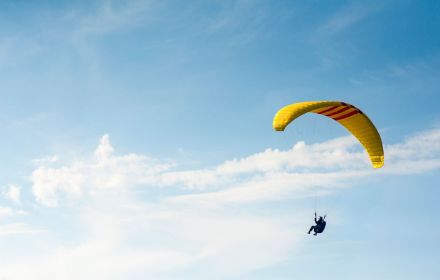person-riding-yellow-parachute