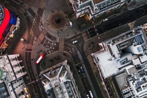 Bird's Eye View Flying Over Piccadilly Circus and Aerial View of London City Streets at Night in London England