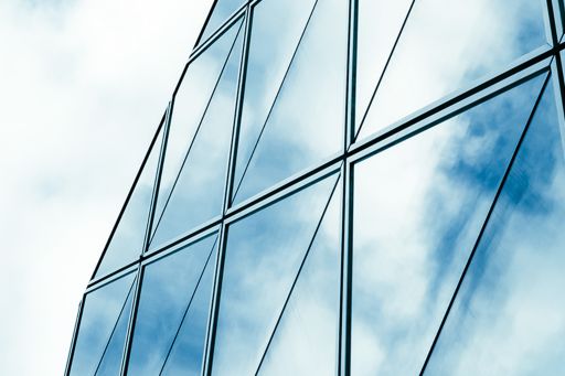 Szklana fasada budynku | Zdjęcie przewodnie wpisu "Nowe uprawnienia organów podatkowych w zakresie badania transgranicznych restrukturyzacji"
