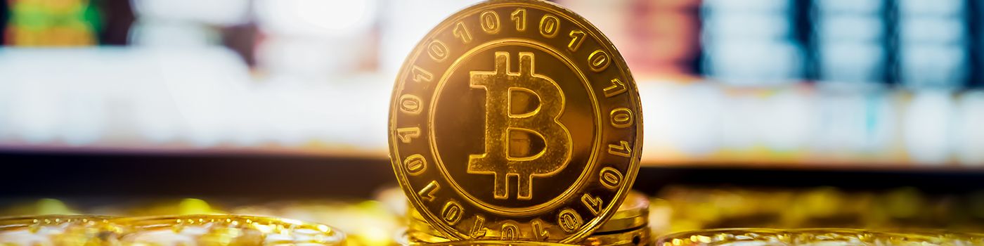 Bitcoin na tle wielu monet i ekranów