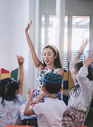 preschool students raise hands in the class