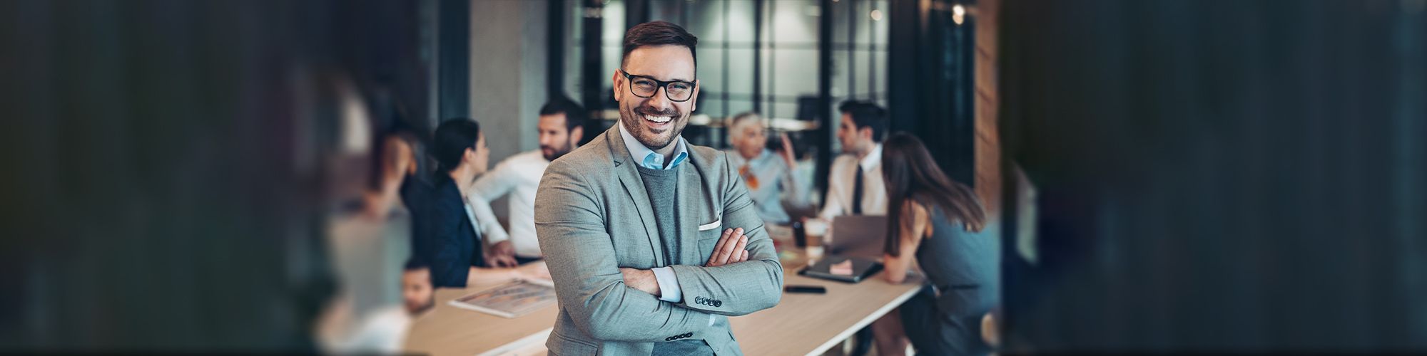 Hombre joven sonriendo en frente a un equipo de trabajo