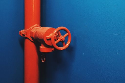 Red Pipeline With Safety Valve Against Blue Wall