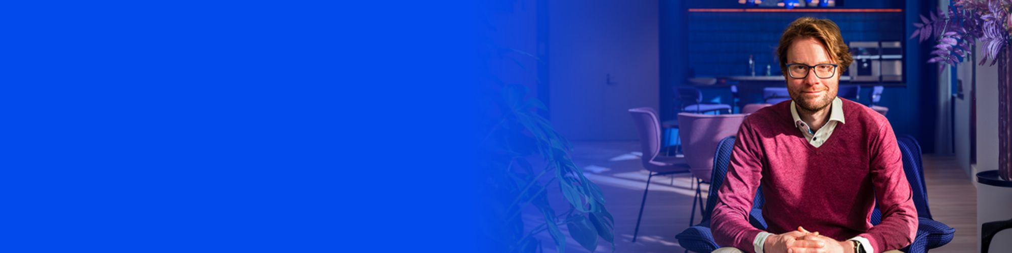 man zittend met bril