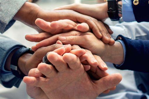 Männer in Anzügen legen Hände übereinander