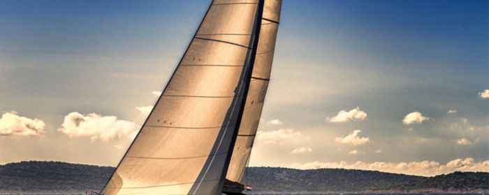 Sailboat moving in the open sea at sunset