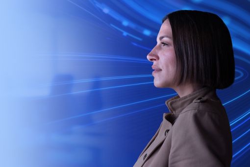 Side profile of woman with blue swirling data behind