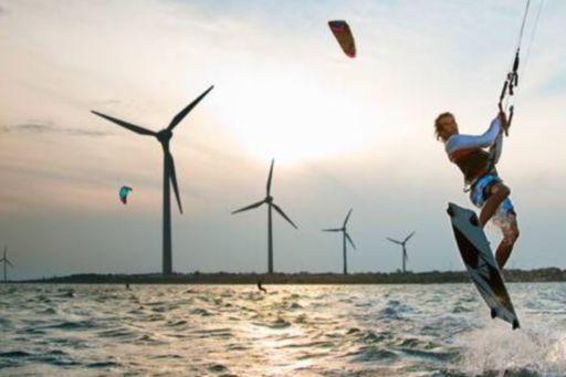 Man surfing by windmills