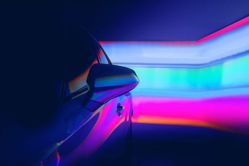 Silhouette of a car in front of neon lights