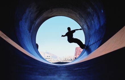 Silhouette of man skateboarding in tunnel
