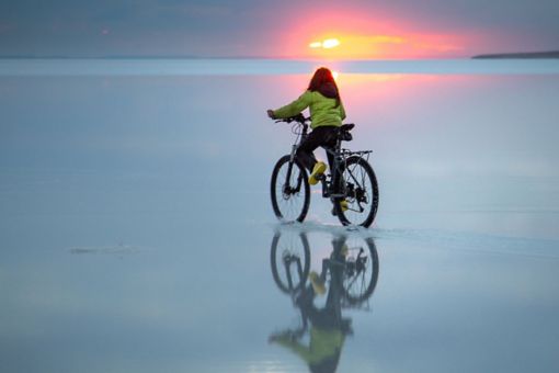 Small girl riding bicycle on beach