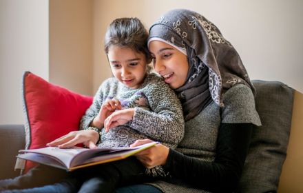 Girl wearing hijab sits with sister