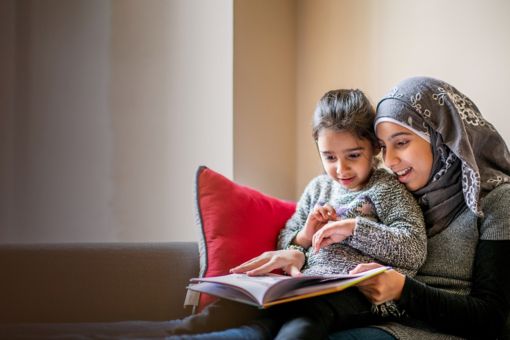 Girl wearing hijab sits with sister