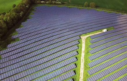 Solar panels surrounded by green field