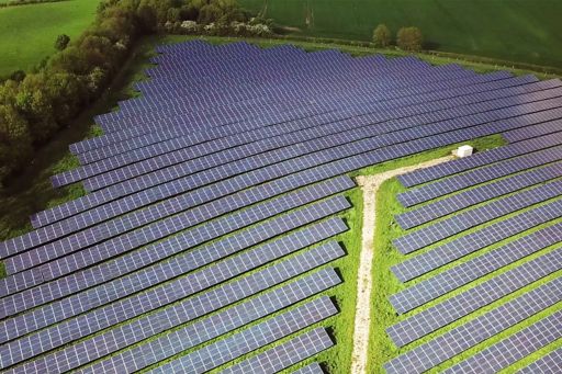Solar panels surrounded by green field