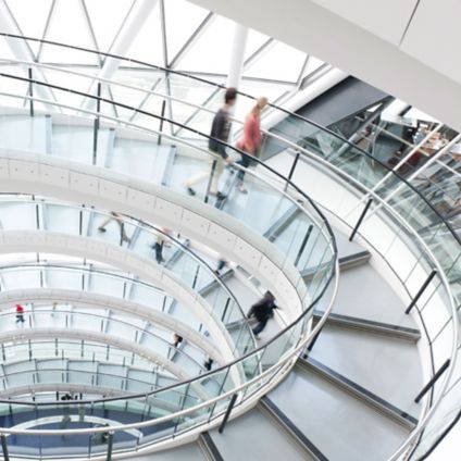 Spiral staircase with people walking down with motion blur