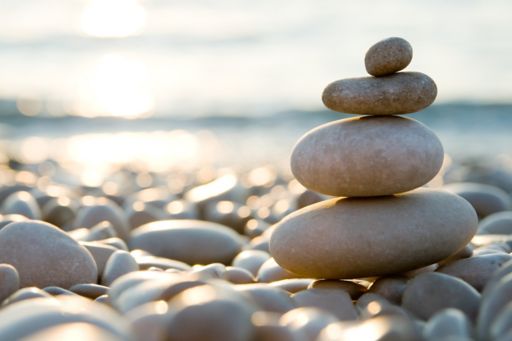 Balancing Stones on Pebble Beach during Sunset