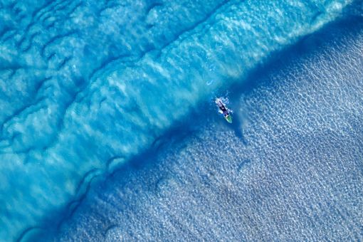 Aerial view of surfer riding waves