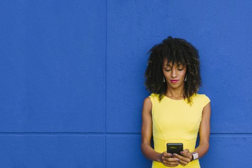 Business woman leaning against a blue background