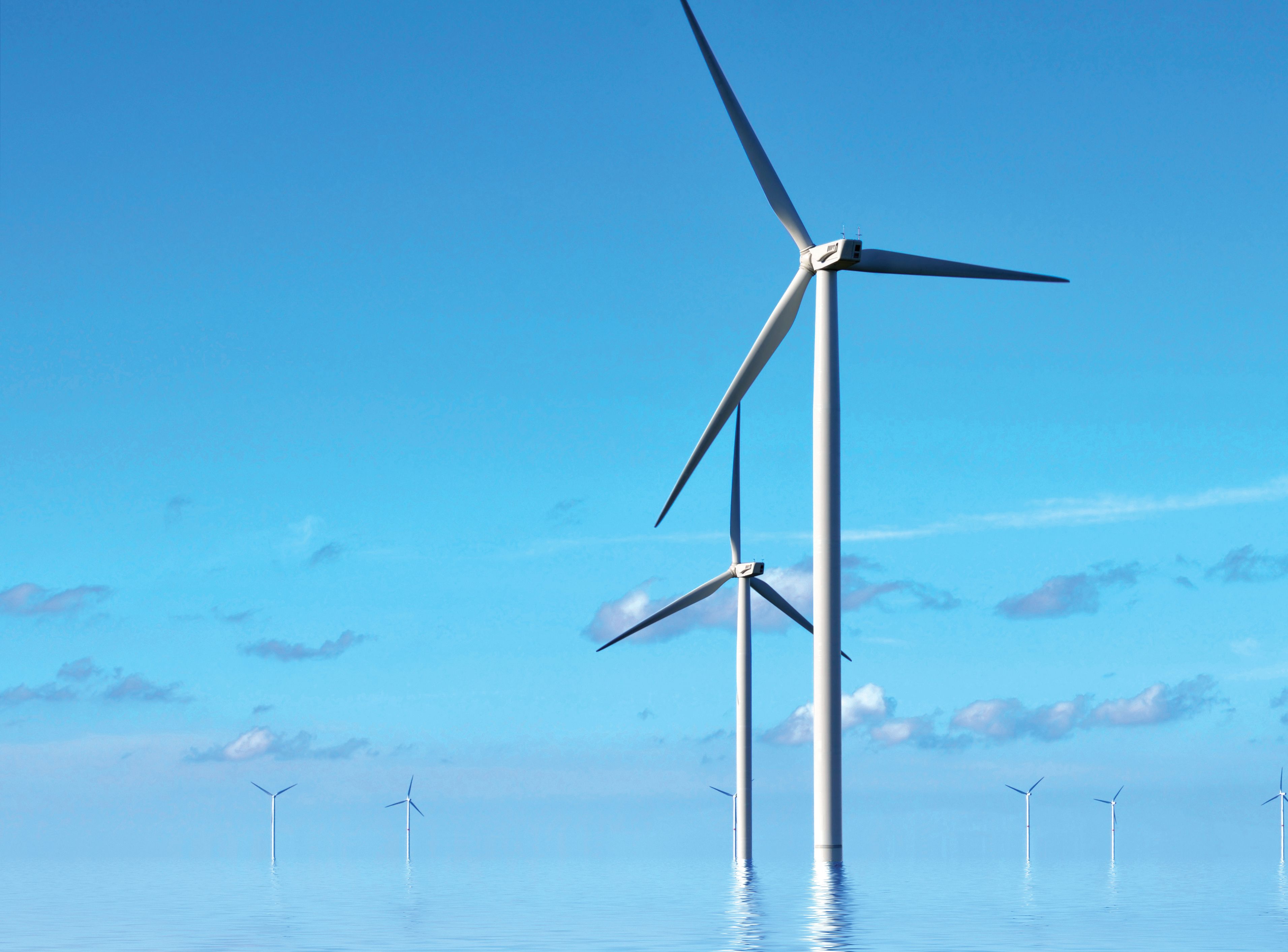 Wind turbines in the sea against a blue sky in the early morning