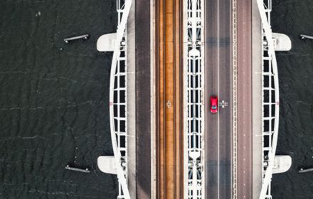 Top view bridge over sea with red car banner