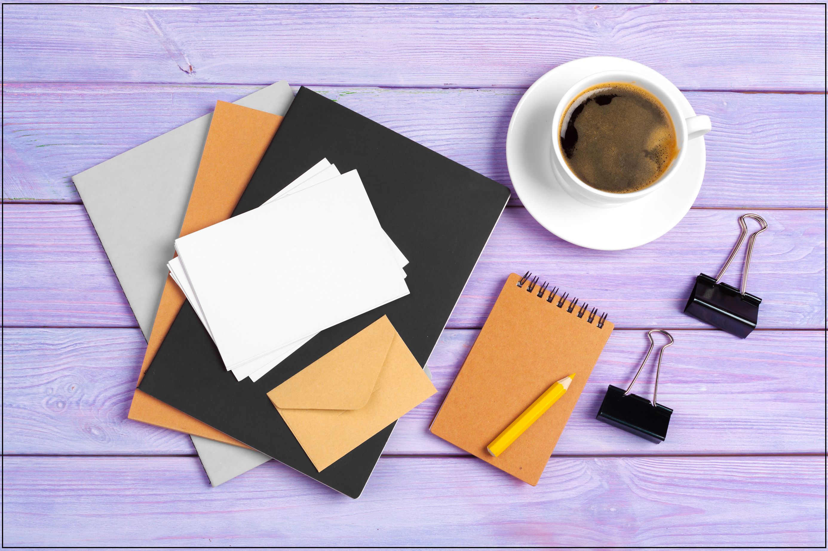 Open notebook with cup of coffee on wooden desk