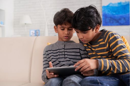 Two boys watching something on tablet device