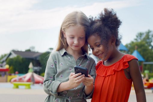 Children using phone smiling