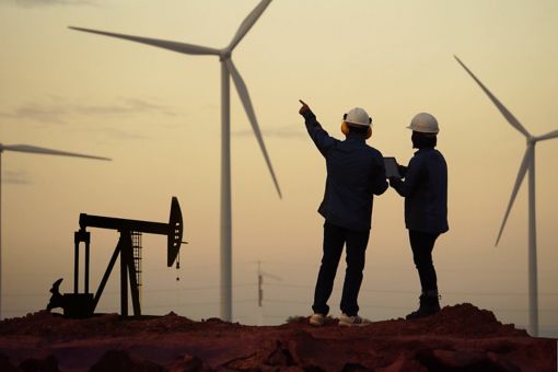 Two construction workers pointing towards windmill