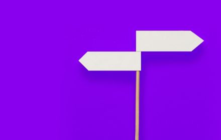 Two-directional sign on purple background