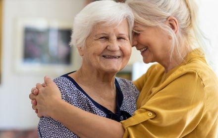 two elderly woman hugging each other