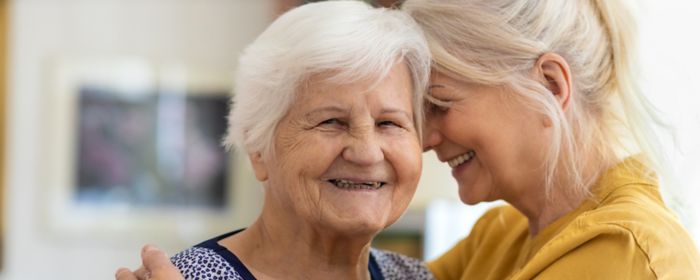 two elderly woman hugging each other