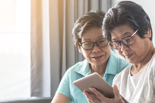 Two elderly women using tablet