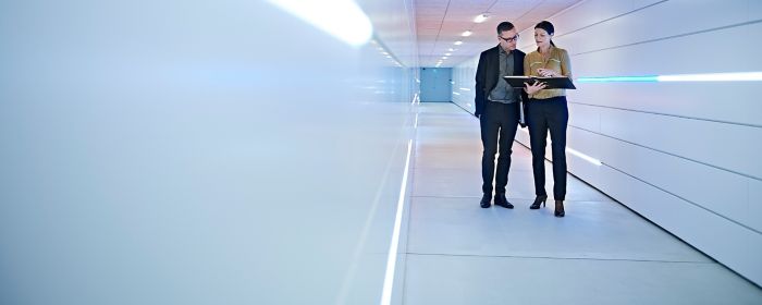 Two people discussing down hallway
