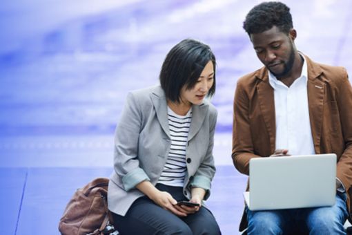 two people looking at laptop banner