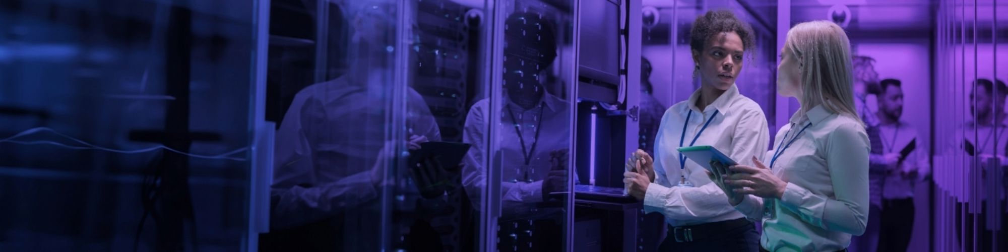 Two women looking at each other whilst in a server room