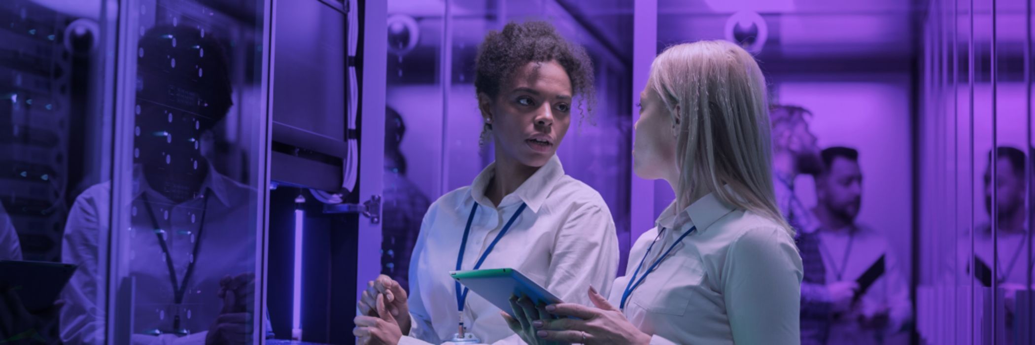 Two women looking at each other whilst in a server room