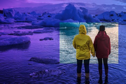 Two people watching floating icebergs