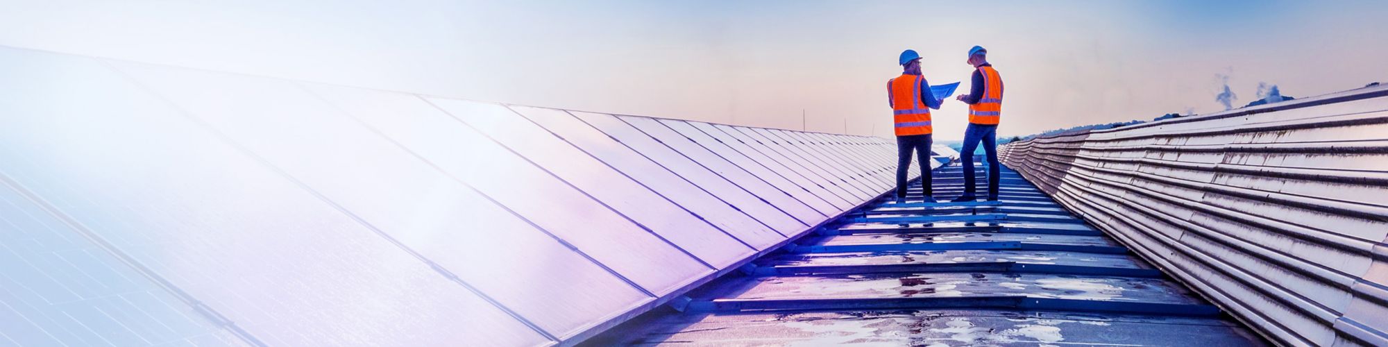 Two technicians assessing rooftop solar panels