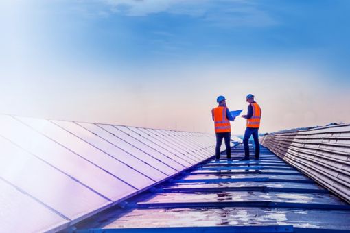 Two technicians assessing rooftop