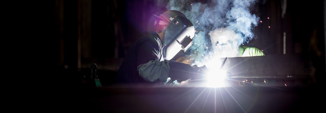 Two welding workers working at night