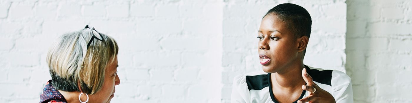 Two women talking while working